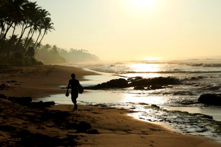 silhouette of person walking on seashore photo