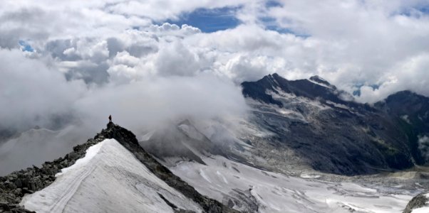 person standing on top of mountain covered with snow photo