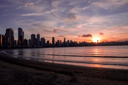 city buildings near ocean water during sunset photo
