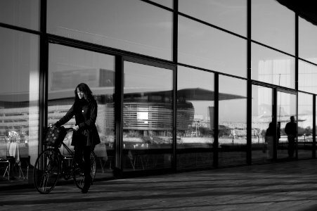 grayscale photography of woman holding bicycle photo