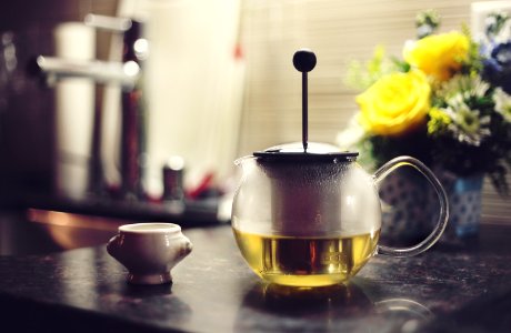 teapot filled with yellow liquid on table photo