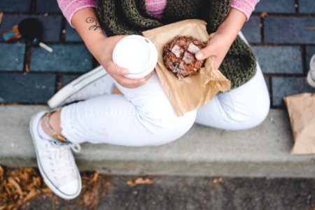 person sitting while holding white tumbler photo