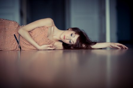 woman wearing pink dress lying on cement photo