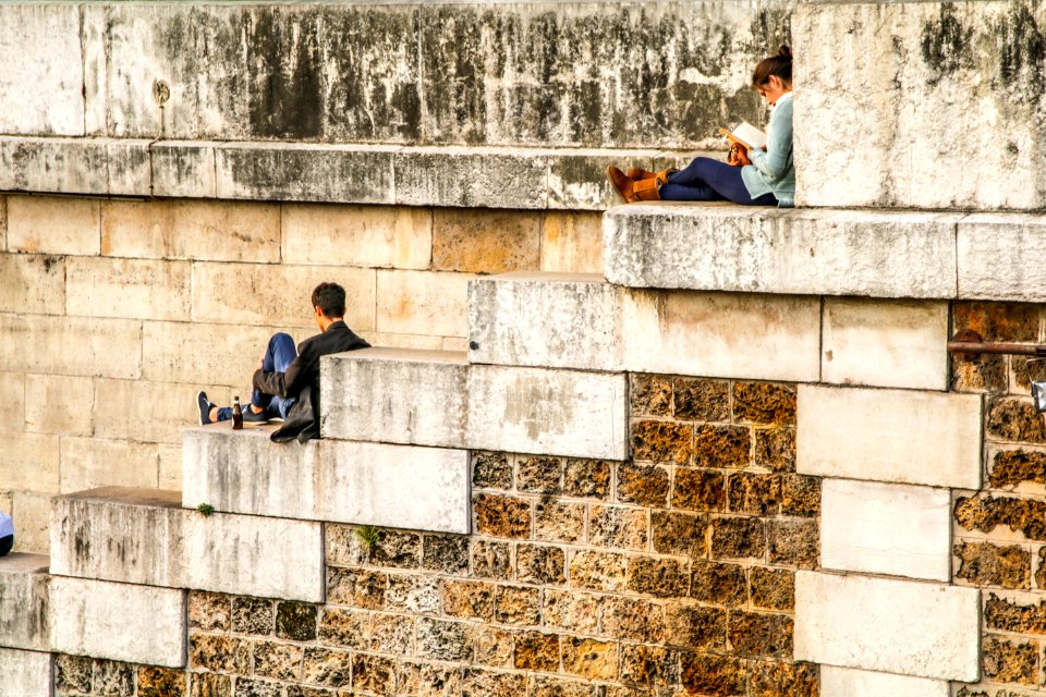 man sitting on staircase behind woman sitting on highest staircase