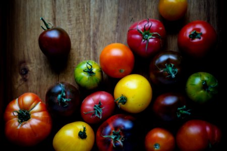 assorted-color tomatoes on brown wooden surface photo