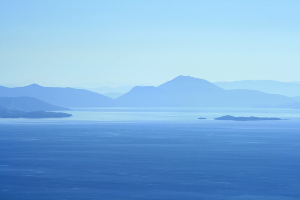 calm water beside mountains at daytime