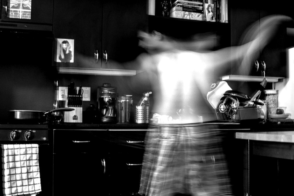 man moving at the kitchen in grayscale photography