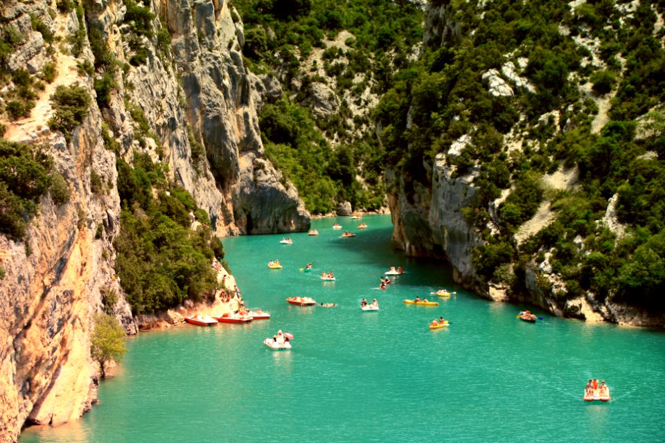yachts sailing on water between tall mountains