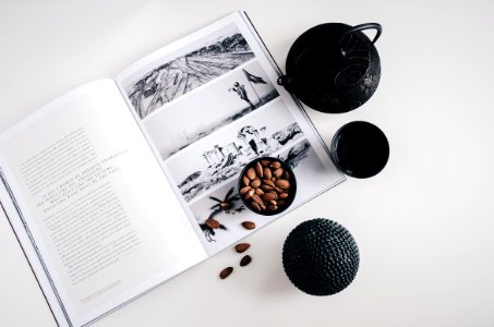 selective color photo of teapot and teacup on book