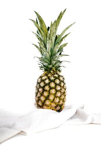 yellow and green pineapple fruit on white textile