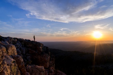 person standing on mountain cliff photo