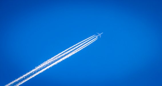 white airplane flying under the blue sky photo