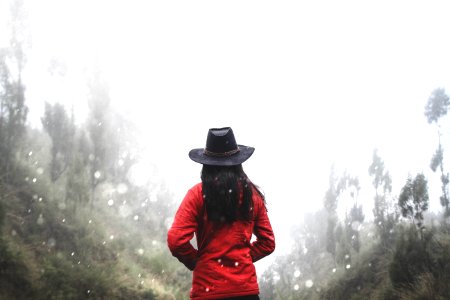 woman in red shirt standing near forest