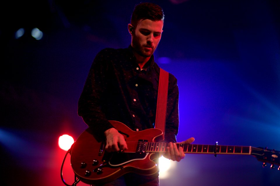 man playing black electric guitar