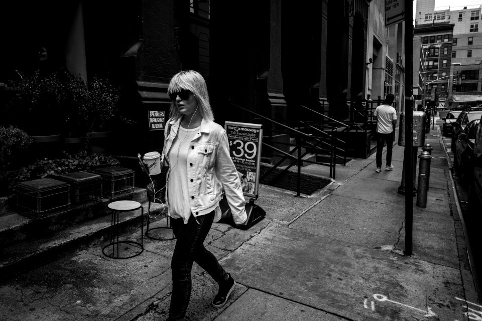 woman walking on pathway near concrete building