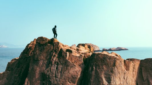 man stands on top of mountain photo