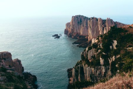 gray and green rock formation near sea during daytime