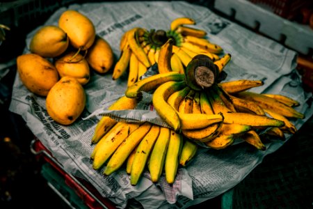 mangoes and bananas on newspaper photo