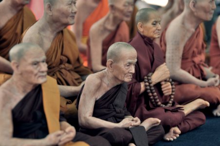 monks sitting on floor while praying photo