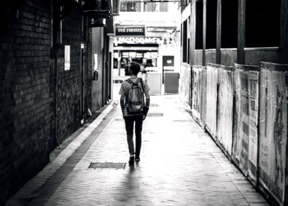man walking between concrete buildings photo