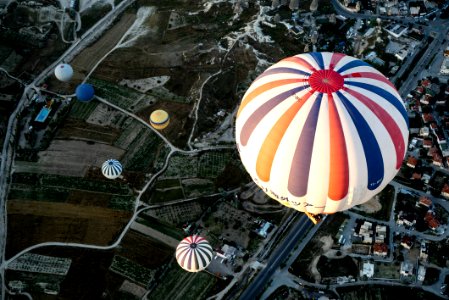 white and blue hot air balloon floating on city photo
