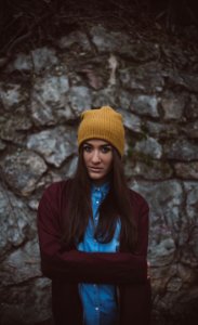 woman wearing brown knit cap standing in front of gray wall photo