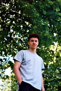 man putting his hand inside his pocket under the tree