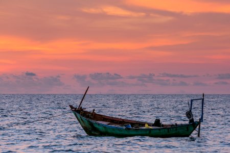 green boat on body of water during golden hour photo