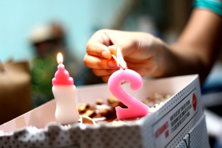 person lighting number 2 candle