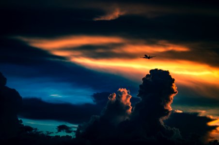 silhouette of plane under cloudy skies photo