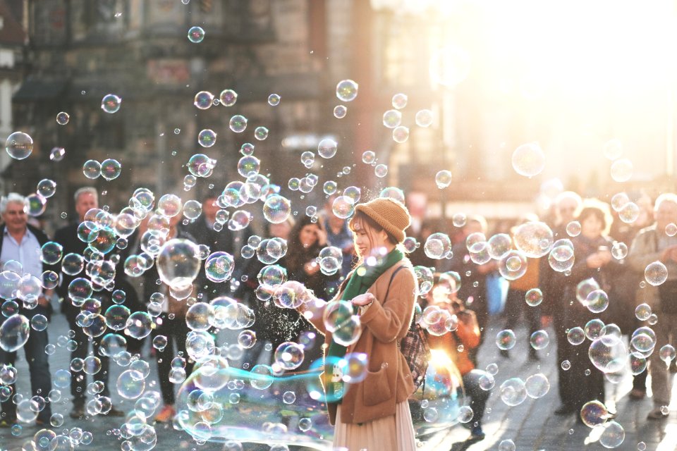 woman standing outdoor surrounded by bobbles during daytime