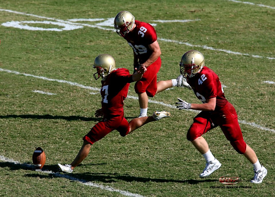 three football players running towards football ball at field during daytime