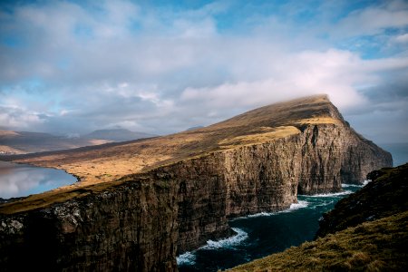 brown cliff near body of water under eblue sky