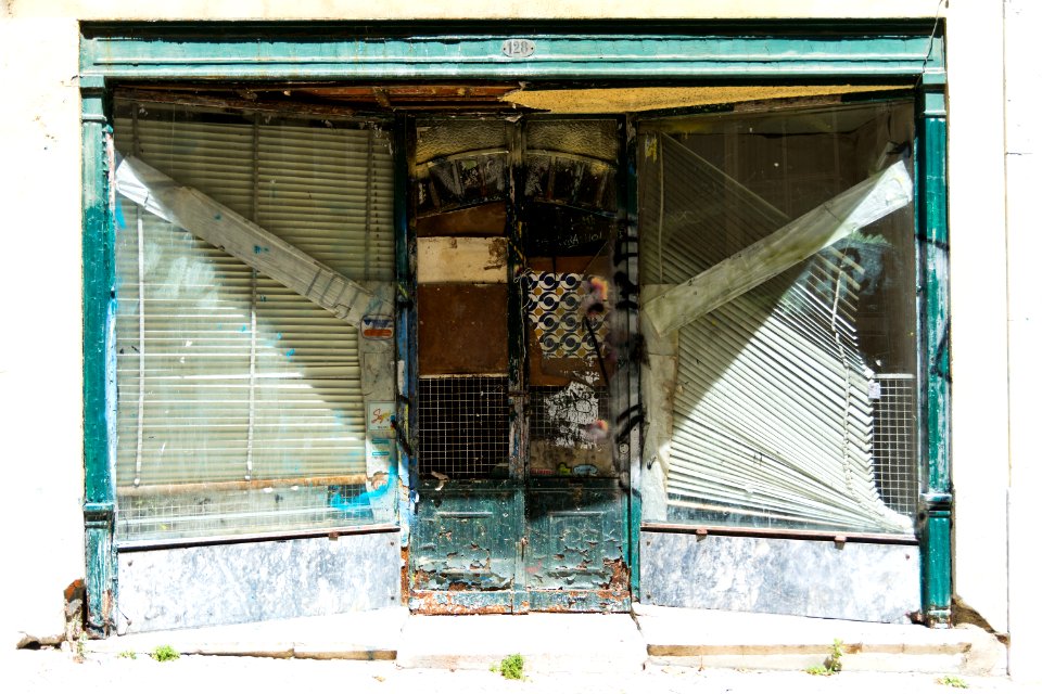 abandoned building with white venetian blinds on window