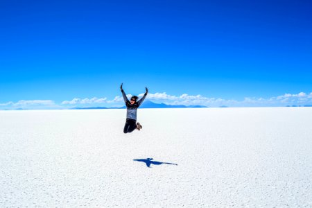 woman jumping under blue skyt photo