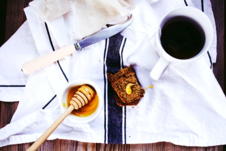 flat lay photography of white knife, honey dipper on bowl, and coffee mug photo