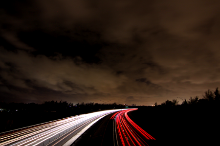 timelapse photography of passing cars on road at nighttime photo