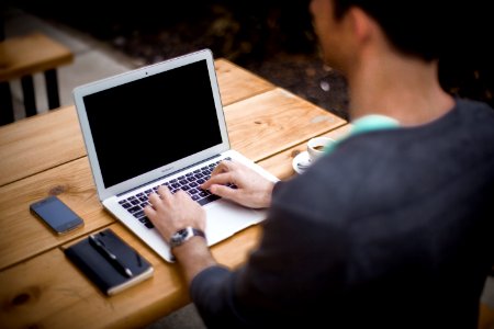 man in front of laptop computer in shallow focus photography photo
