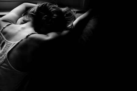 grayscale photography of woman laying on pillow