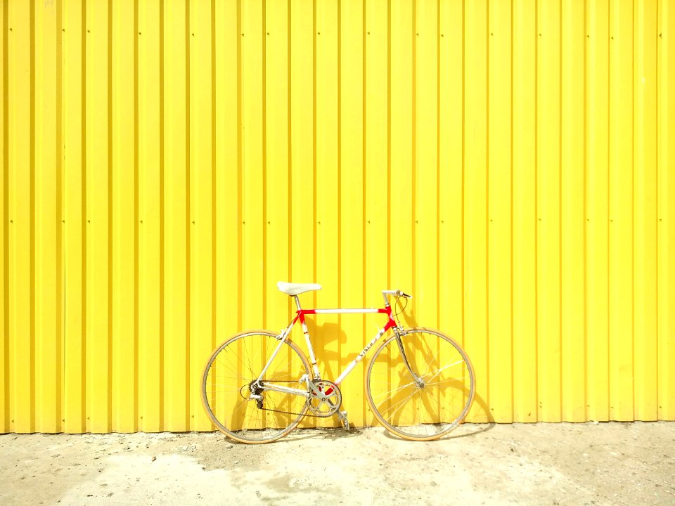 white and red hardtail bike on yellow wall
