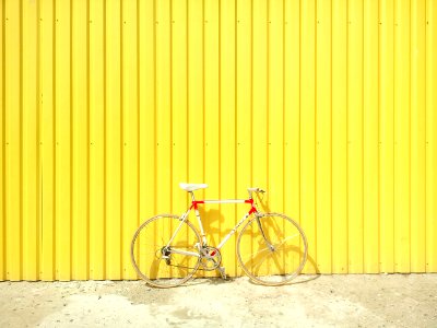 white and red hardtail bike on yellow wall photo