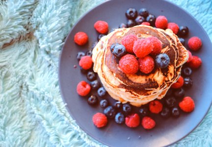 pancakes with blueberries and raspberries on gray plate photo