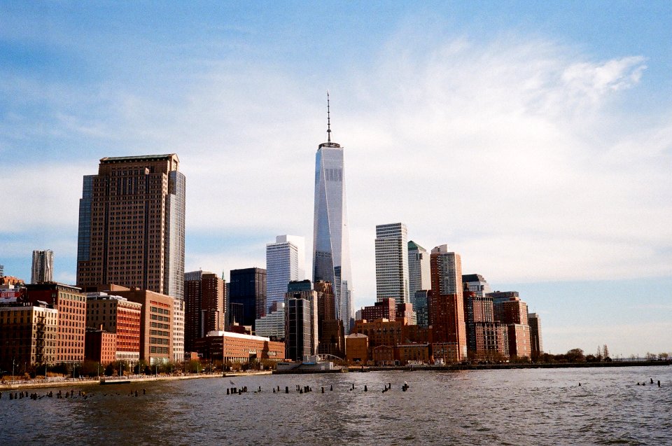 city near body of water under white and blue sky during daytime photgraphy photo