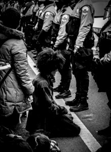 person kneeling before police officers