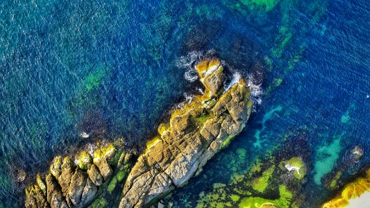 aerial view photography of rock formations surrounded by ocean during daytime photo