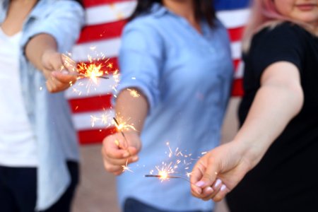 three person holding sparklers photo