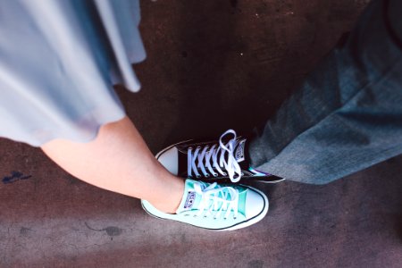 person wearing teal and white Converse All-Star low-top photo