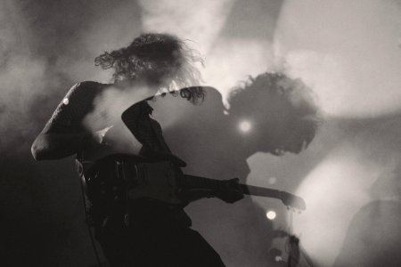 A black-and-white shot of a man playing electric guitar in double exposure photo