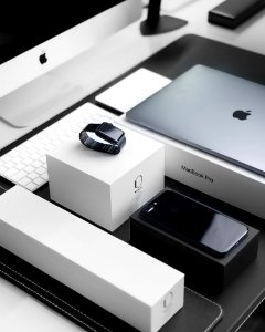 space black case Apple Watch, silver MacBook Pro, jet black iPhone 7 Plus, and silver iMac with corresponding boxes photo