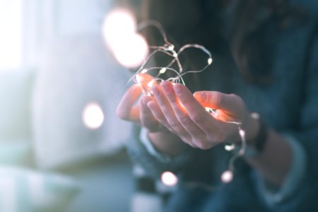 shallow focus photograph of person holding string lights photo
